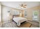 Cozy bedroom with a ceiling fan, two windows, and door leading to the outdoors at 1912 Parkside Village Dr, Clayton, NC 27520