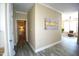 Inviting hallway featuring fresh paint, gray flooring, and decor, leading to a cozy sitting room at 1912 Parkside Village Dr, Clayton, NC 27520
