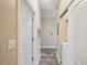 Hallway with wood-look floors leads to laundry area with sliding door at 1912 Parkside Village Dr, Clayton, NC 27520