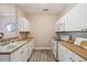 The kitchen features white cabinets, ample counter space, and wood-look floors at 1912 Parkside Village Dr, Clayton, NC 27520