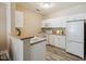 Well-lit kitchen featuring white cabinets, modern appliances, and wood-look flooring at 1912 Parkside Village Dr, Clayton, NC 27520