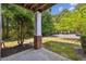 View of the patio with concrete flooring, brick pillar base, and well-manicured landscaping at 1912 Parkside Village Dr, Clayton, NC 27520