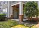 Exterior view of a patio with brick accents, green door, and verdant landscaping at 1912 Parkside Village Dr, Clayton, NC 27520