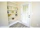 A shelving unit next to a door, decorated with books and decorative items in a well-lit space at 1912 Parkside Village Dr, Clayton, NC 27520