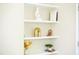 White shelving unit decorated with books, plants, and decorative objects in a well-lit space at 1912 Parkside Village Dr, Clayton, NC 27520