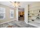 Sunlit sitting area with wood floors, a ceiling fan, and built-in bookshelves at 1912 Parkside Village Dr, Clayton, NC 27520