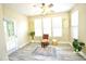 Inviting sitting room featuring a comfortable chair, large windows, ceiling fan, and stylish rug at 1912 Parkside Village Dr, Clayton, NC 27520