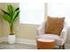 Well-lit sitting room showcasing a comfortable chair and ottoman next to a lush green potted plant at 1912 Parkside Village Dr, Clayton, NC 27520