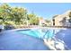 An outdoor swimming pool surrounded by lounge chairs and mature trees under a blue sky at 1912 Parkside Village Dr, Clayton, NC 27520