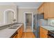 An open kitchen featuring wood cabinets and a view of a laundry area with modern appliances at 201 Presque Isle Ln, Chapel Hill, NC 27514