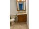 Bathroom featuring a vanity with oak cabinets, sink, mirror, and toilet at 210 Crest Rd, Henderson, NC 27536