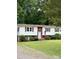 Charming home exterior with a well-manicured lawn and mature trees at 210 Crest Rd, Henderson, NC 27536