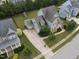 Overhead shot of the property highlighting its spacious driveway, attached garage, and a backyard with a playground at 212 Preatonwood Dr, Apex, NC 27539