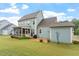 Backyard showcasing the house, a screened porch, a patio, and a lush lawn at 212 Preatonwood Dr, Apex, NC 27539