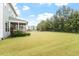 Spacious backyard with lush green grass, mature trees, and a play set at 212 Preatonwood Dr, Apex, NC 27539