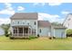 Backyard showcasing the house, a screened porch, a patio, and a lush lawn at 212 Preatonwood Dr, Apex, NC 27539