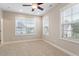 Neutral-toned bedroom has two windows, plush carpet, and a modern ceiling fan at 212 Preatonwood Dr, Apex, NC 27539