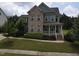Charming two-story home featuring a combination of brick and blue siding, complemented by a well-manicured front yard at 212 Preatonwood Dr, Apex, NC 27539