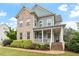 Attractive two-story home with brick accents, a welcoming front porch, and well-maintained green lawn at 212 Preatonwood Dr, Apex, NC 27539