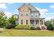 Charming two-story home with a brick and blue exterior, front porch, and well-manicured landscaping at 212 Preatonwood Dr, Apex, NC 27539