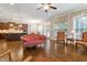 Open-concept living room showcasing hardwood floors, a kitchen view, and abundant natural light from large windows at 212 Preatonwood Dr, Apex, NC 27539