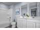 Clean bathroom featuring dual sinks, white cabinetry, and a shower-tub combo at 220 Gianna Dr, Lillington, NC 27546