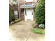 Exterior front door entrance with small green bushes and a concrete entryway at 2221 Delaney Dr # 112, Burlington, NC 27215