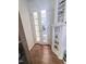 Hallway with hardwood floors, built in shelves and glass doors leading to another room at 2221 Delaney Dr # 112, Burlington, NC 27215
