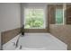 Bright bathroom with garden tub and window overlooking lush greenery at 238 Langford Valley Way, Cary, NC 27513