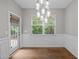 Elegant dining room with hardwood floors, decorative lighting, wainscoting, and a large window offering natural light at 238 Langford Valley Way, Cary, NC 27513