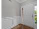 Welcoming entryway featuring wainscoting, hardwood floors, and a view of the front door and sidelight at 238 Langford Valley Way, Cary, NC 27513