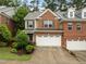 Charming two-story townhome featuring a brick and siding facade with a two-car garage and manicured landscaping at 238 Langford Valley Way, Cary, NC 27513