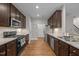 Well-equipped kitchen featuring granite countertops, dark cabinetry, stainless steel appliances, and hardwood flooring at 238 Langford Valley Way, Cary, NC 27513