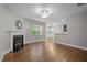 Bright living room with hardwood floors, fireplace, neutral paint, and views into the dining and kitchen areas at 238 Langford Valley Way, Cary, NC 27513