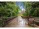 An inviting walking bridge surrounded by lush green trees creates a nature-filled experience at 238 Langford Valley Way, Cary, NC 27513