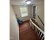 Hallway with hardwood floors, window, and access to stairs at 2507 Chapel Hill Rd, Durham, NC 27707