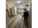A view of the kitchen featuring a fridge, light wood floors, and a window above the sink at 2507 Chapel Hill Rd, Durham, NC 27707