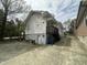 Exterior back view of a white house with basement access, small deck, and alley access at 2511 Chapel Hill Rd, Durham, NC 27707