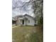Quaint white home with a cozy covered front porch, surrounded by trees and a small, grassy lawn in a residential area at 2511 Chapel Hill Rd, Durham, NC 27707