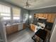 Functional kitchen with stainless steel appliances, wooden cabinets, and a view through a large window at 2511 Chapel Hill Rd, Durham, NC 27707