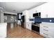 Stylish kitchen featuring white cabinets, stainless steel appliances, and wood-look flooring at 2517 Newbold St, Raleigh, NC 27603