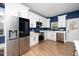 Modern kitchen boasts stainless steel appliances, white cabinets, and a dark blue accent wall at 2517 Newbold St, Raleigh, NC 27603