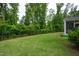 Spacious backyard featuring a well-manicured lawn, mature trees, and a black metal fence at 2521 Heathland Farm Dr, Fuquay Varina, NC 27526