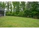 Lush green backyard with mature trees and privacy fence, perfect for outdoor activities at 2521 Heathland Farm Dr, Fuquay Varina, NC 27526