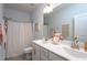 Well-lit bathroom featuring a double vanity, shower with curtain, and modern fixtures at 2521 Heathland Farm Dr, Fuquay Varina, NC 27526