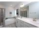 Bright bathroom features double vanity, soaking tub, and tiled shower with glass doors at 2521 Heathland Farm Dr, Fuquay Varina, NC 27526