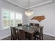 This dining room features a modern chandelier, natural light, and a decorative North Carolina outline at 2521 Heathland Farm Dr, Fuquay Varina, NC 27526
