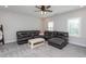 Spacious living room with a comfortable leather sectional sofa, neutral carpet, and plantation shutters at 2521 Heathland Farm Dr, Fuquay Varina, NC 27526