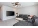 Spacious carpeted living room with a large sectional sofa, TV, and ceiling fan at 2521 Heathland Farm Dr, Fuquay Varina, NC 27526