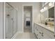 Bright bathroom with double sinks, a glass-enclosed shower, and laundry room visible through the doorway at 2537 Cedar Hedge Ct, Apex, NC 27523